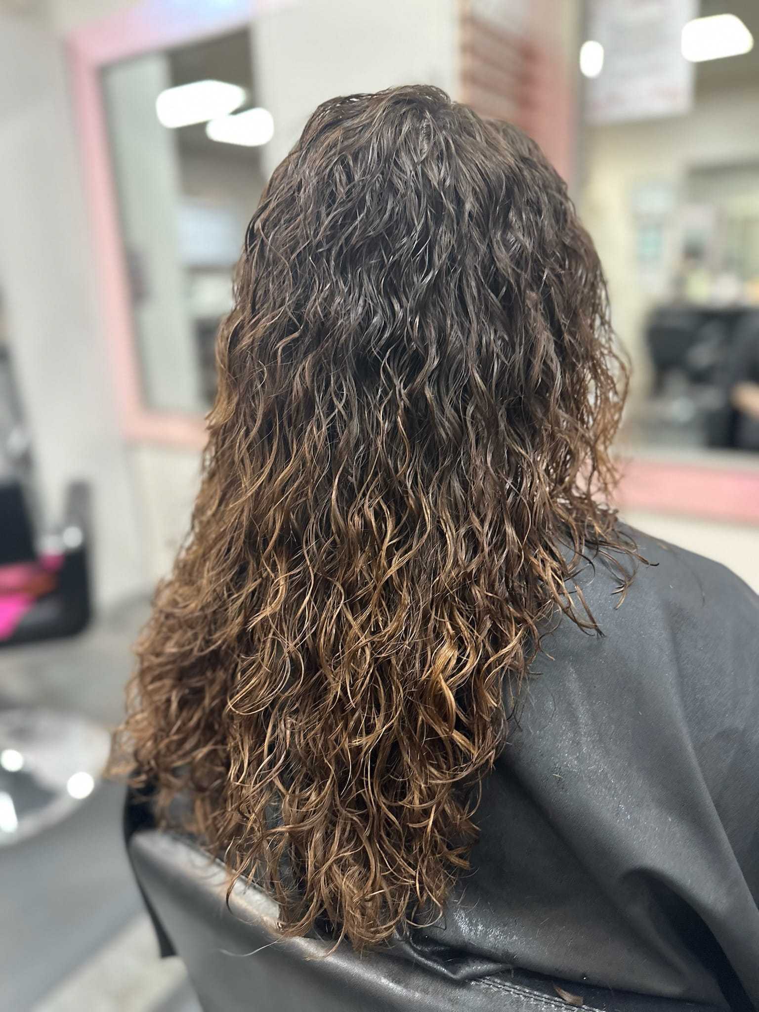 Curly hair after a salon treatment, styled with layers and volume.