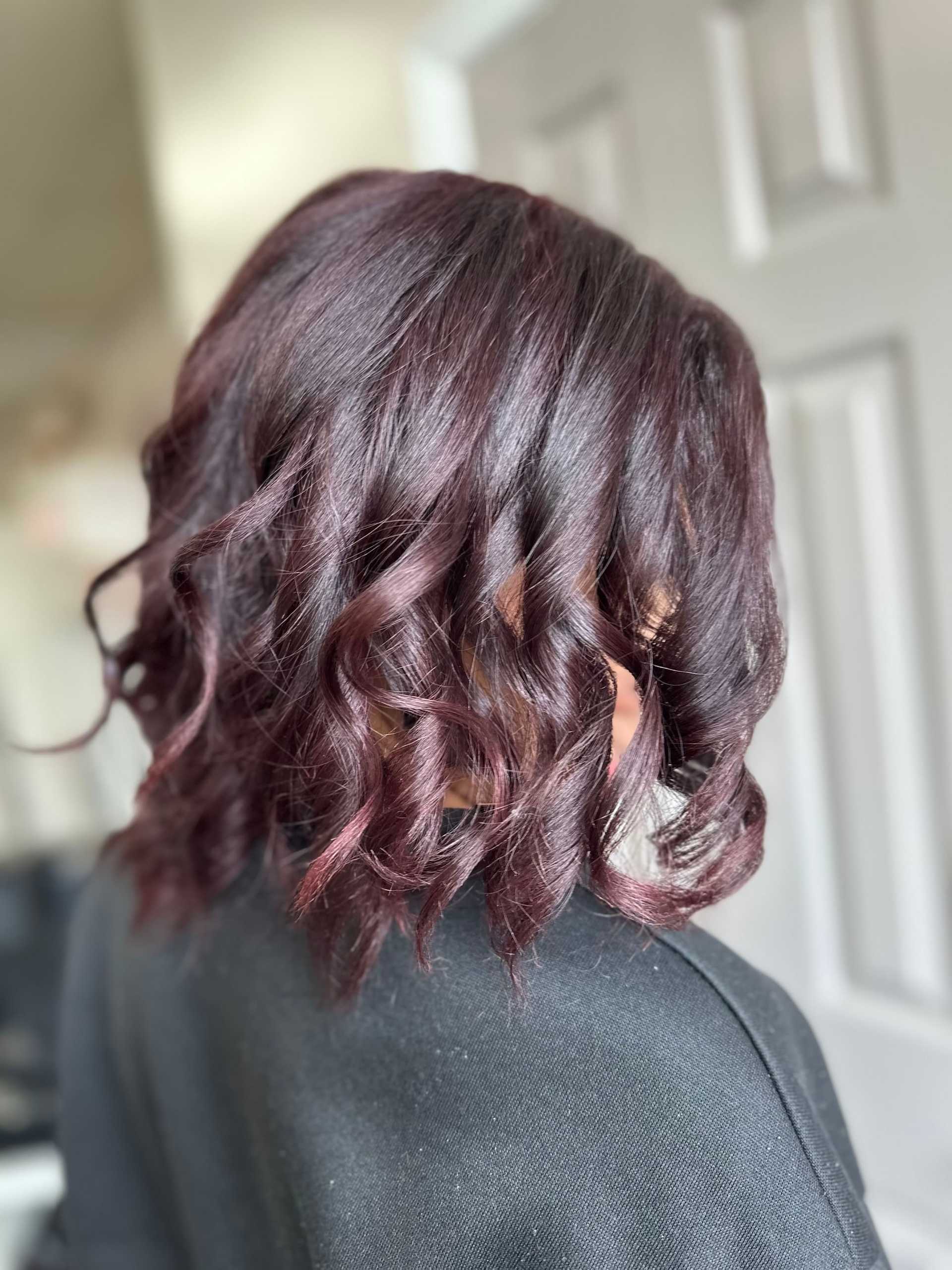 Curled short hair in rich burgundy, viewed from the back.